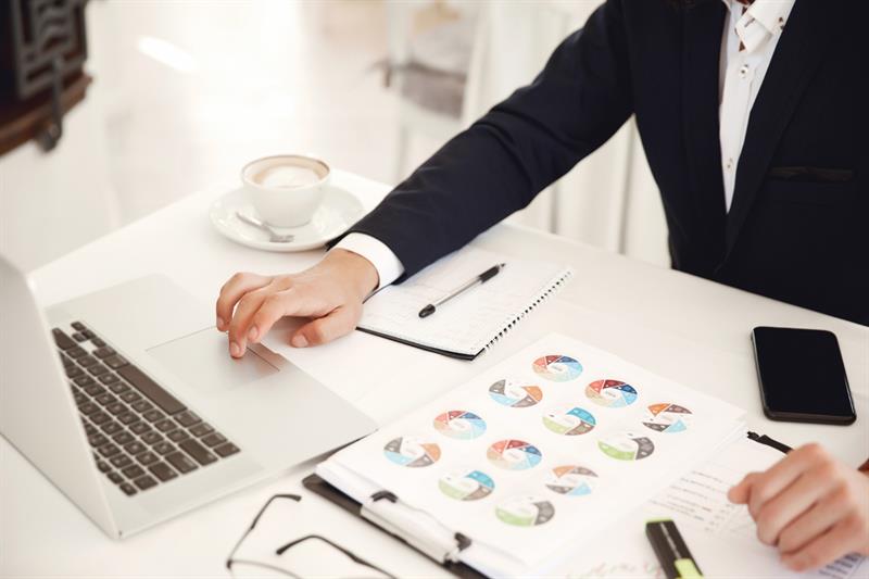 cropped-frontview-businessman-working-place-restaurant-with-laptop-cellphone-diagrams-latte